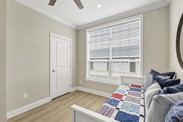 bedroom with light wood-type flooring, ornamental molding, baseboards, and multiple windows