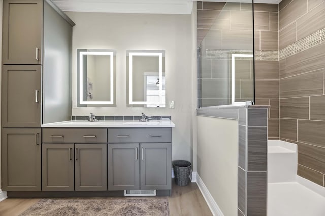 full bathroom featuring visible vents, walk in shower, baseboards, a sink, and double vanity