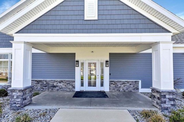 entrance to property with a porch and stone siding