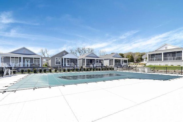 pool featuring fence, a patio, and a residential view