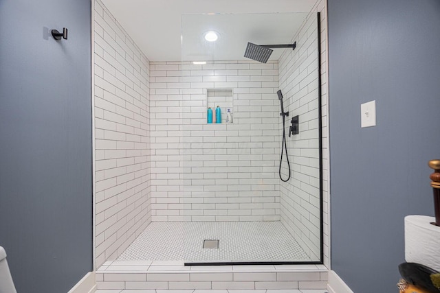 bathroom featuring a shower stall and baseboards