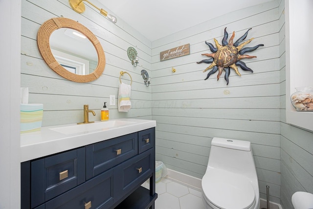 bathroom with wood walls, vanity, toilet, and tile patterned floors