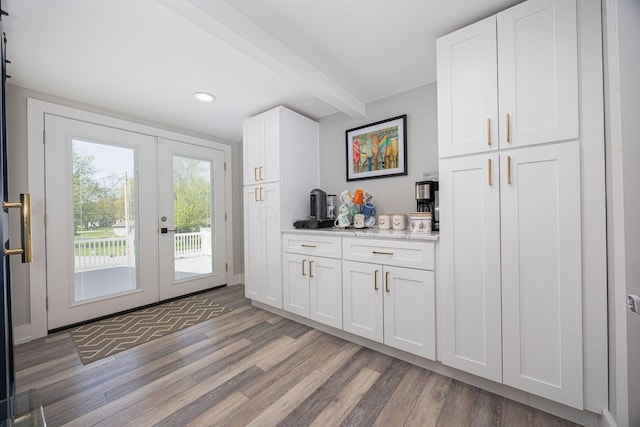 interior space with beam ceiling, recessed lighting, french doors, and light wood-style flooring