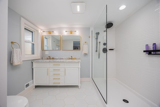bathroom with walk in shower, tile patterned floors, toilet, a sink, and baseboards