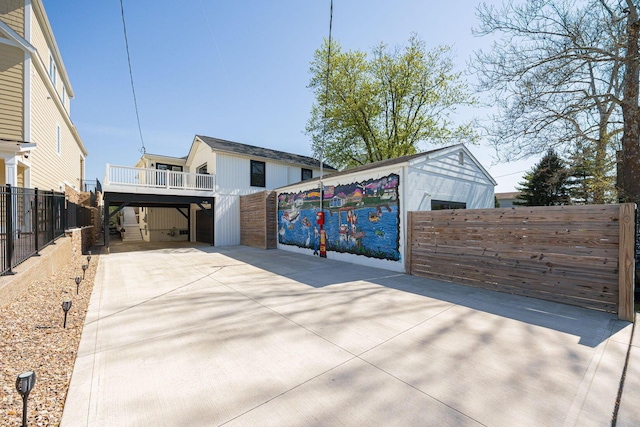 view of home's exterior with fence and driveway