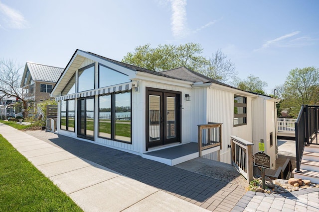 rear view of property with a deck and french doors