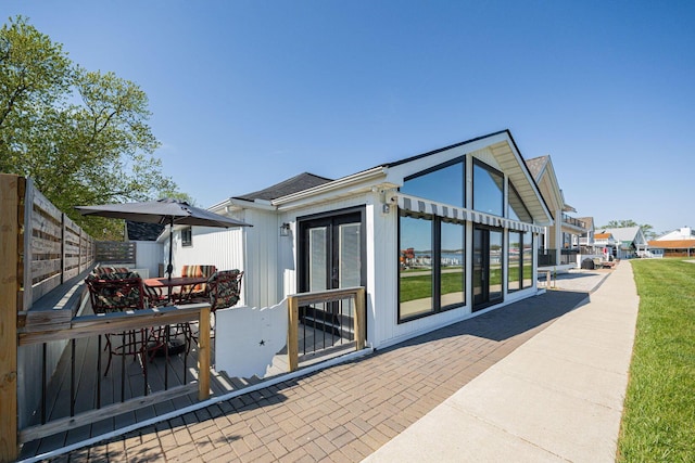back of property with a patio, outdoor dining area, and fence