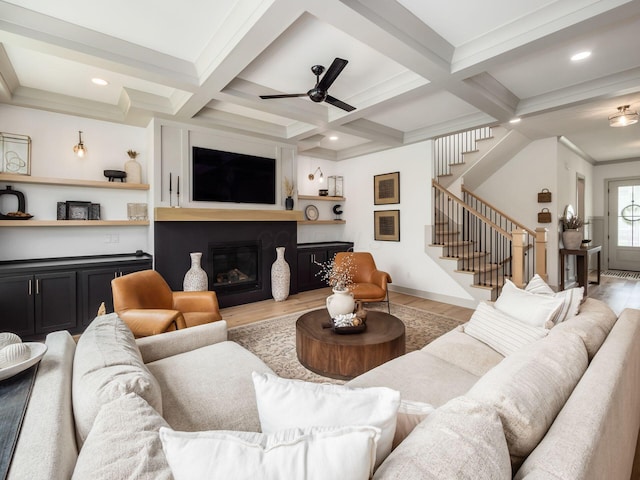 living room with a ceiling fan, a large fireplace, wood finished floors, and stairway