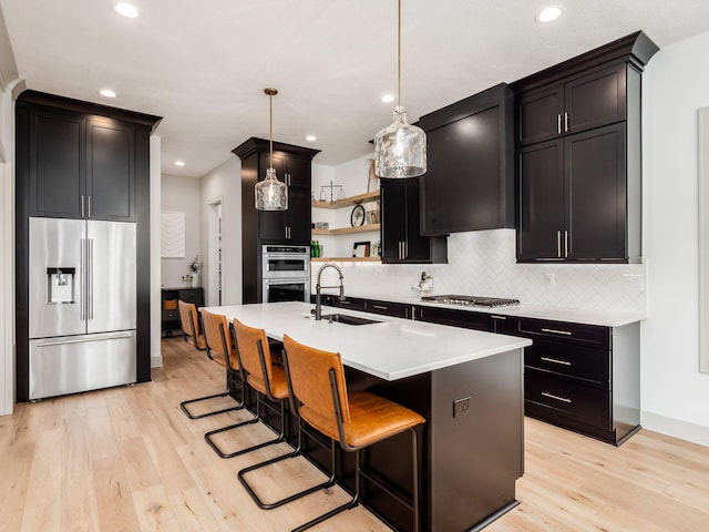 kitchen featuring open shelves, decorative backsplash, a sink, light wood-style flooring, and appliances with stainless steel finishes