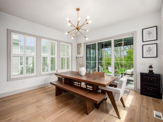 dining area with visible vents, light wood finished floors, baseboards, and an inviting chandelier