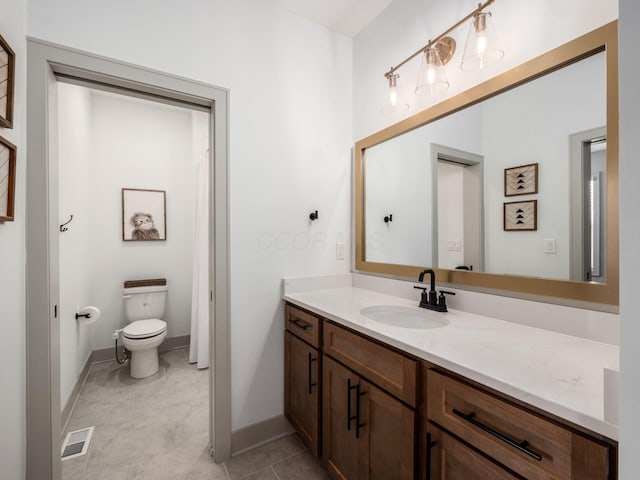 bathroom featuring vanity, baseboards, visible vents, and toilet