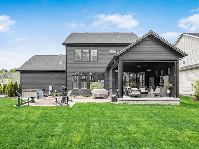 back of house with an outdoor living space with a fire pit, a yard, and a patio area