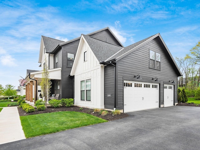 view of home's exterior with board and batten siding, driveway, roof with shingles, a lawn, and an attached garage