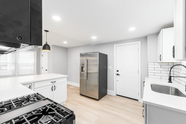 271 S Terrace Ave, Columbus, OH 43204 - kitchen with white cabinets, stainless steel fridge, a sink, light countertops, and gas range oven
