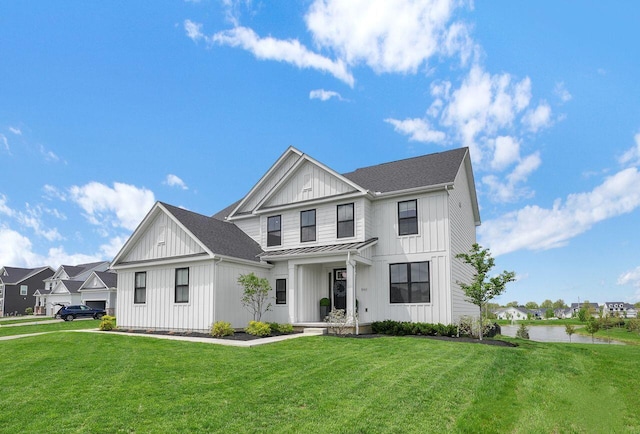modern farmhouse style home with board and batten siding, a standing seam roof, a front yard, and metal roof