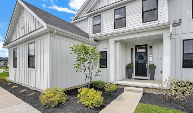 property entrance with a shingled roof and board and batten siding