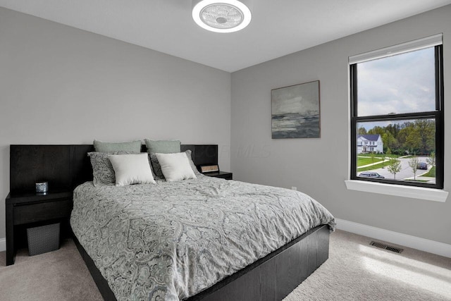 carpeted bedroom with multiple windows, visible vents, and baseboards