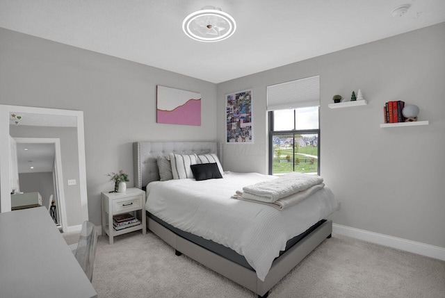 bedroom with light carpet and baseboards