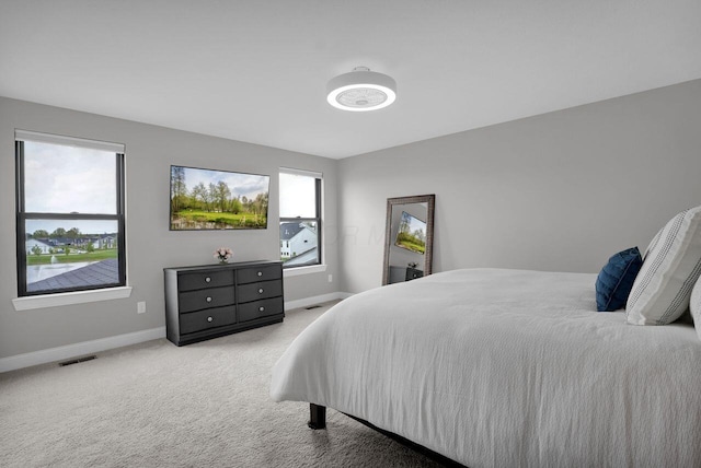carpeted bedroom featuring baseboards and visible vents