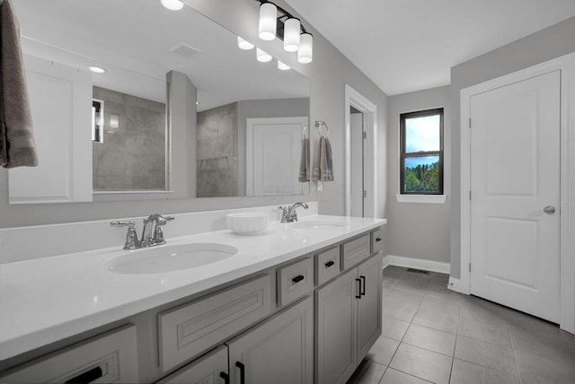bathroom featuring baseboards, tile patterned flooring, double vanity, and a sink