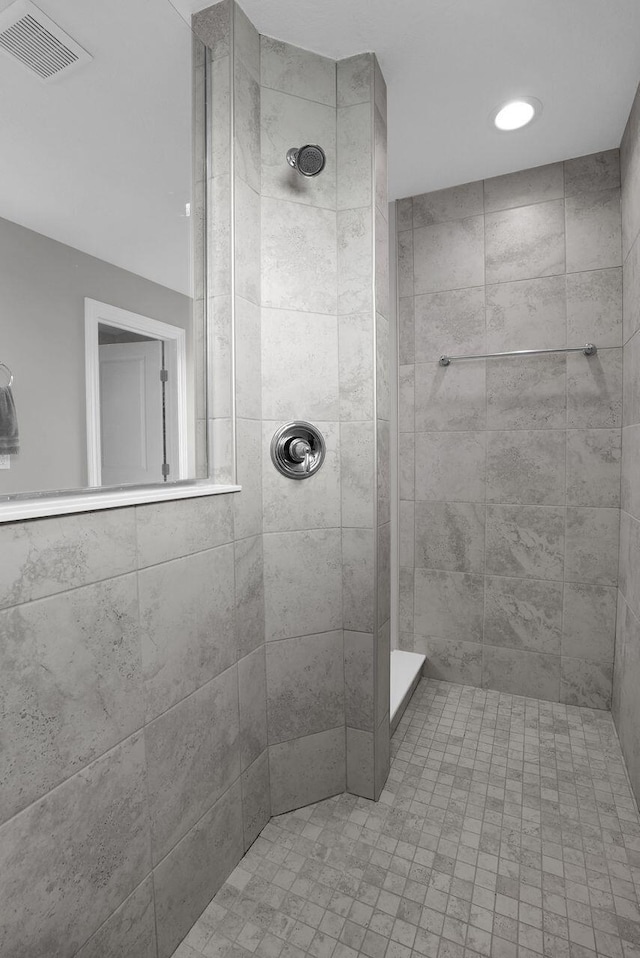 bathroom featuring visible vents and a tile shower