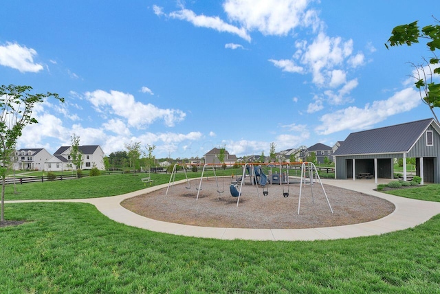 community play area featuring fence, a residential view, and a lawn