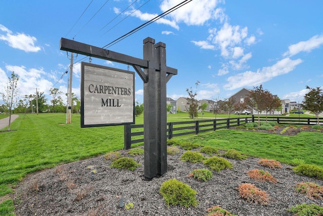 community / neighborhood sign featuring a yard and fence