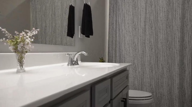 full bathroom with toilet and vanity