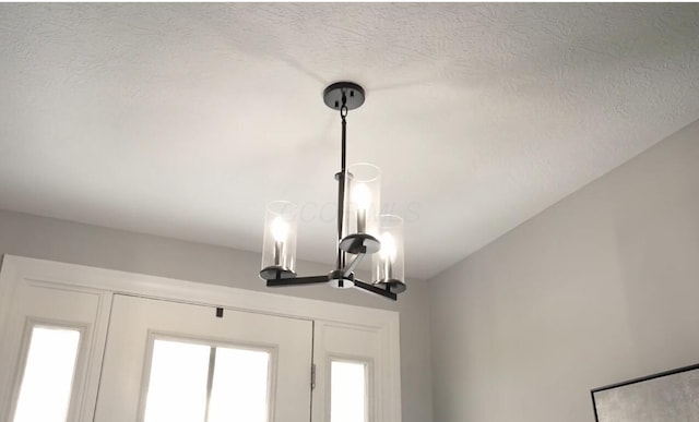 interior details with an inviting chandelier and a textured ceiling
