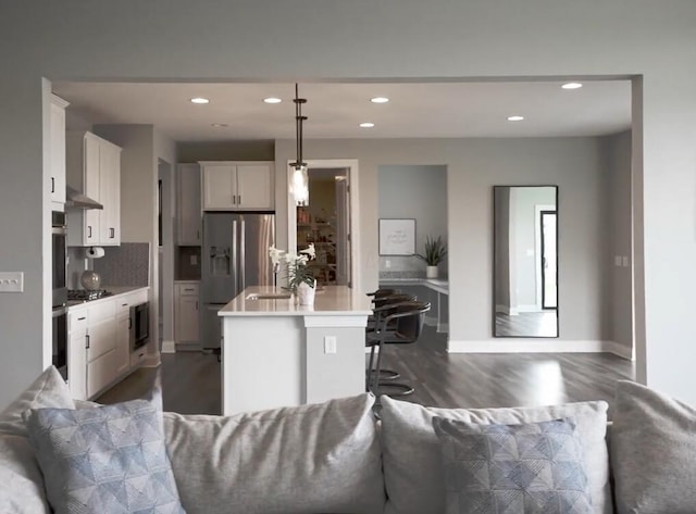 kitchen featuring recessed lighting, open floor plan, appliances with stainless steel finishes, and wood finished floors