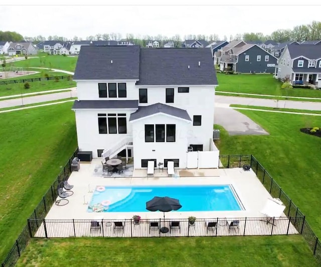 rear view of house featuring a lawn, fence, a patio area, and a residential view