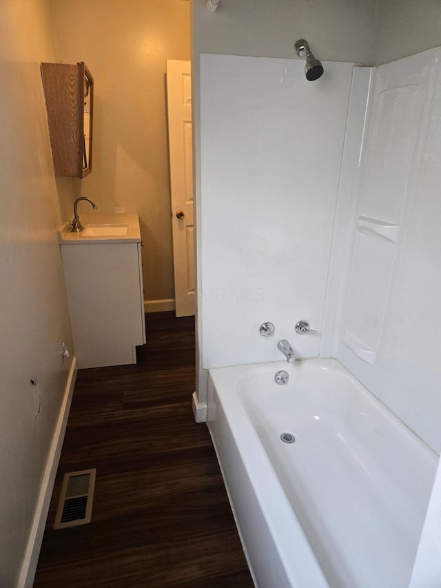 full bathroom featuring vanity, visible vents, baseboards, and wood finished floors