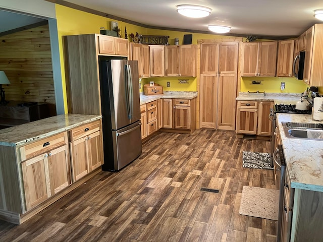 kitchen featuring a peninsula, dark wood-style floors, freestanding refrigerator, visible vents, and light stone countertops