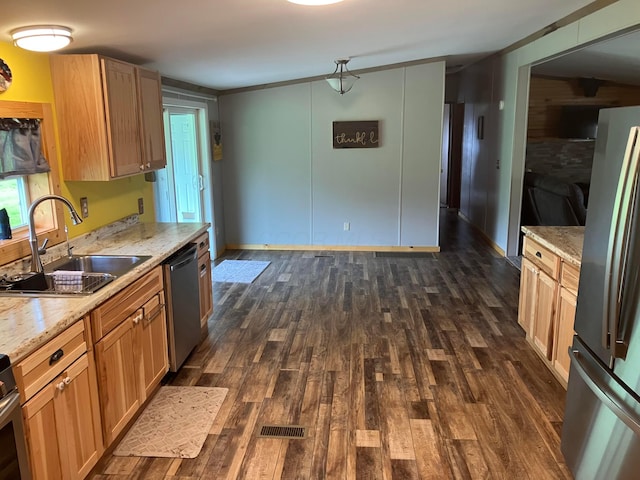 kitchen featuring stainless steel appliances, a sink, dark wood-type flooring, and light stone counters