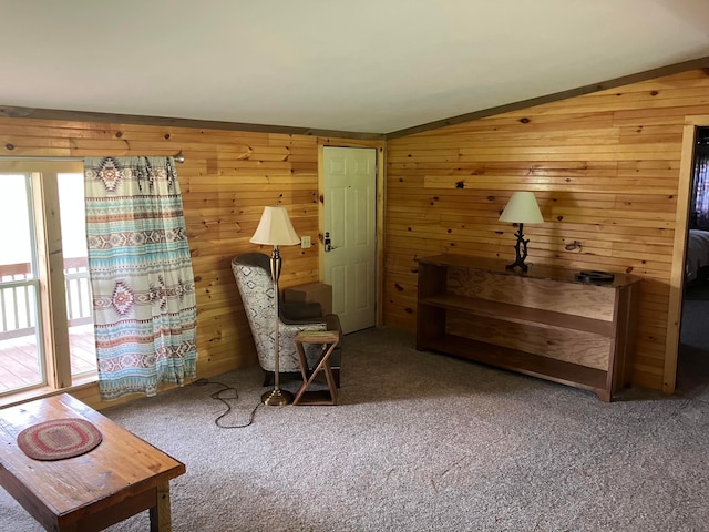 living area with vaulted ceiling, carpet floors, and wood walls