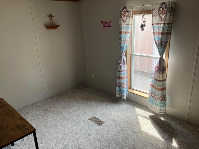 unfurnished room featuring visible vents and carpet