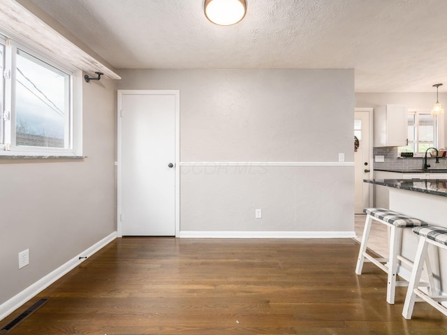 dining room featuring plenty of natural light, visible vents, baseboards, and dark wood finished floors