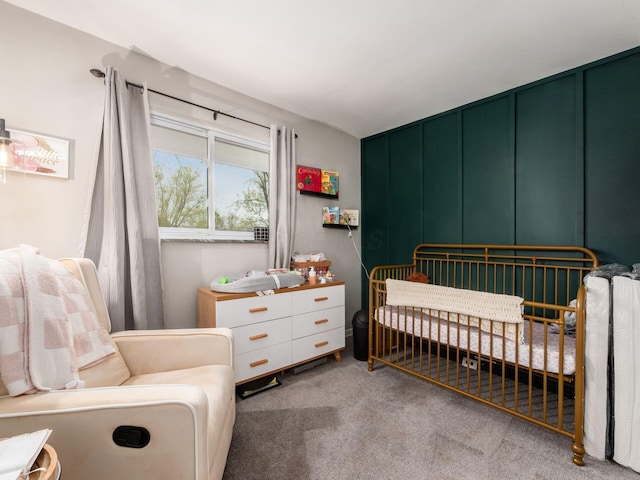 carpeted bedroom with a decorative wall and a crib