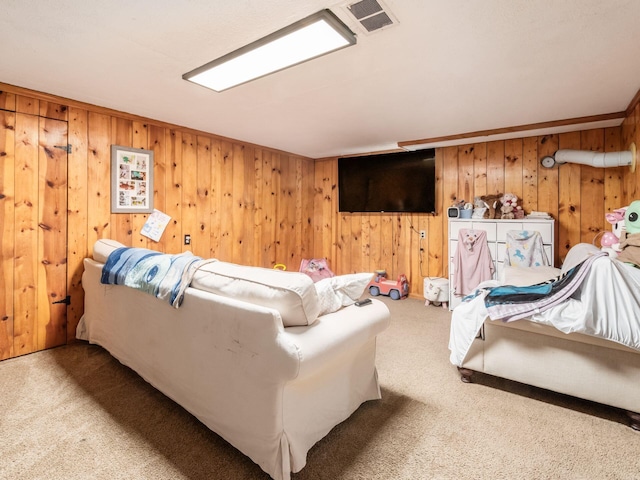 carpeted bedroom with wood walls and visible vents