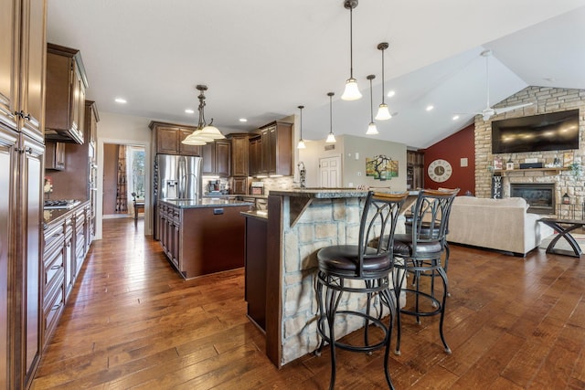 kitchen with stainless steel fridge with ice dispenser, open floor plan, dark wood-type flooring, a kitchen island with sink, and lofted ceiling