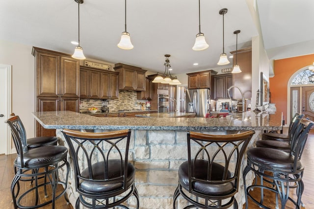 kitchen featuring tasteful backsplash, appliances with stainless steel finishes, and a breakfast bar