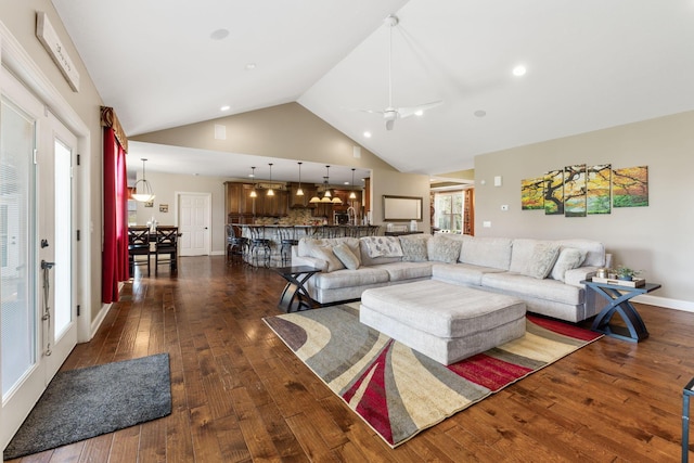 living area featuring dark wood-type flooring, baseboards, high vaulted ceiling, and a ceiling fan