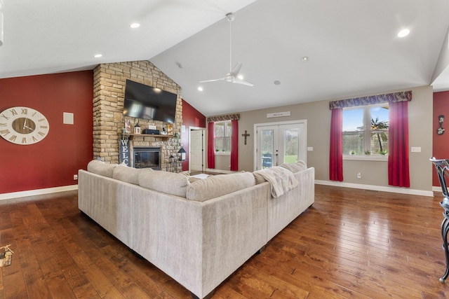 living room featuring a healthy amount of sunlight, a fireplace, a ceiling fan, and vaulted ceiling