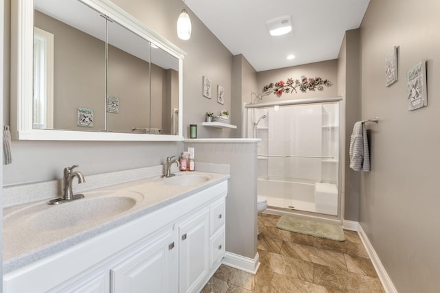full bathroom with a sink, baseboards, and a shower stall