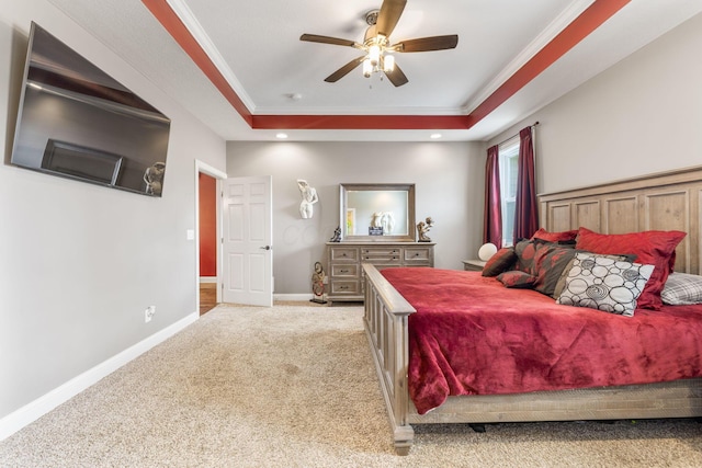 bedroom with baseboards, carpet, a tray ceiling, and crown molding