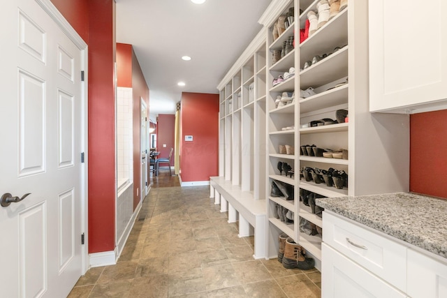 mudroom with stone finish flooring, recessed lighting, and baseboards