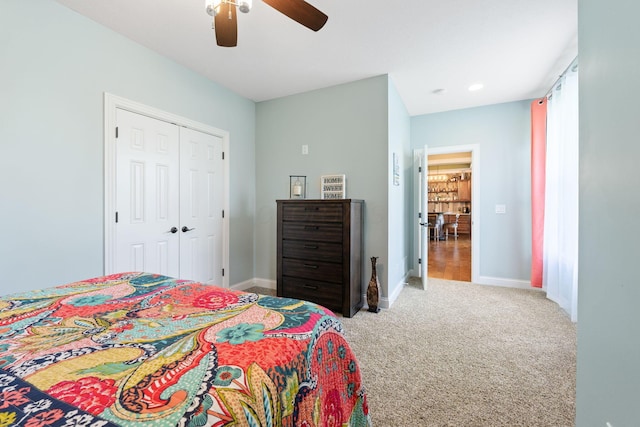 bedroom with a closet, baseboards, a ceiling fan, and carpet floors