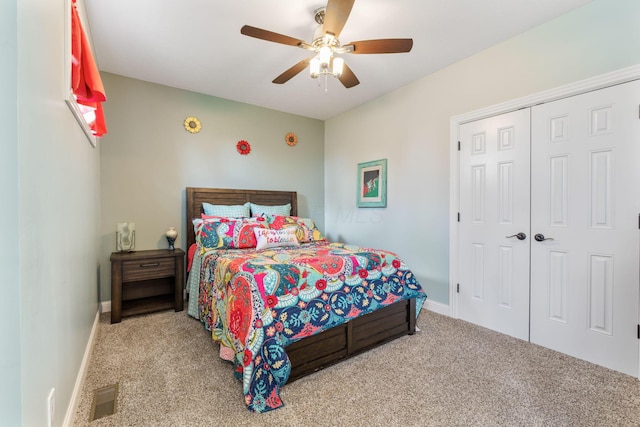 carpeted bedroom with a closet, baseboards, a ceiling fan, and visible vents