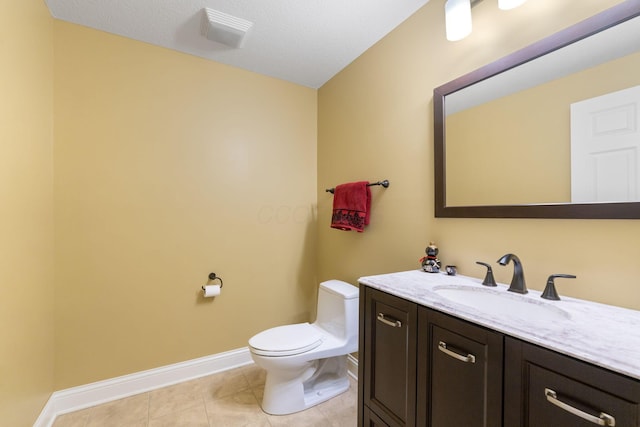 bathroom with toilet, tile patterned floors, vanity, and baseboards