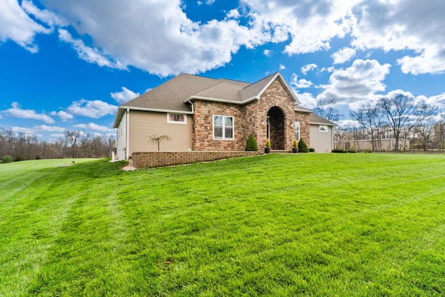 view of front of property featuring roof with shingles, fence, a front yard, and stone siding